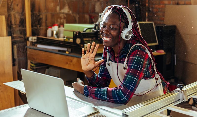 LaptopSawTableWavingSmilingHeadphones crop1000